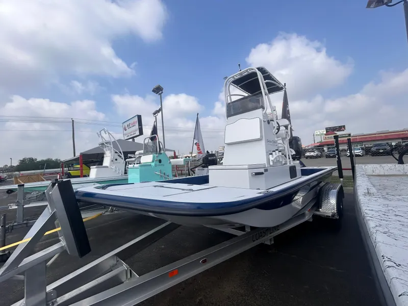 Slide: The Image of 2025 Shallow Stalker CAT211PRO boat on trailer under cloudy sky. - 1