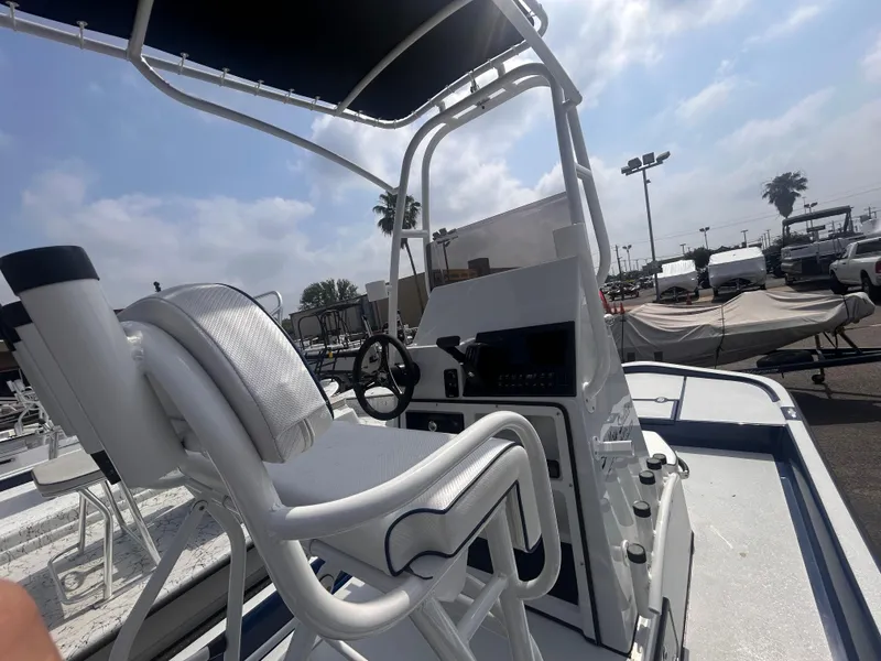 Slide: The Image of 2025 Shallow Stalker CAT211PRO boat with white seating and steering console, docked outdoors. - 8