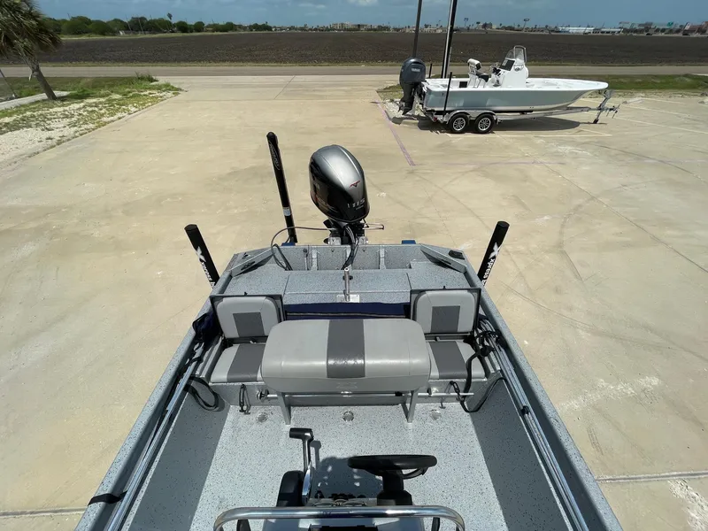 Slide: The Image of 2019 Xpress XP20CC boat with outboard motor, parked on concrete lot under clear sky. - 11