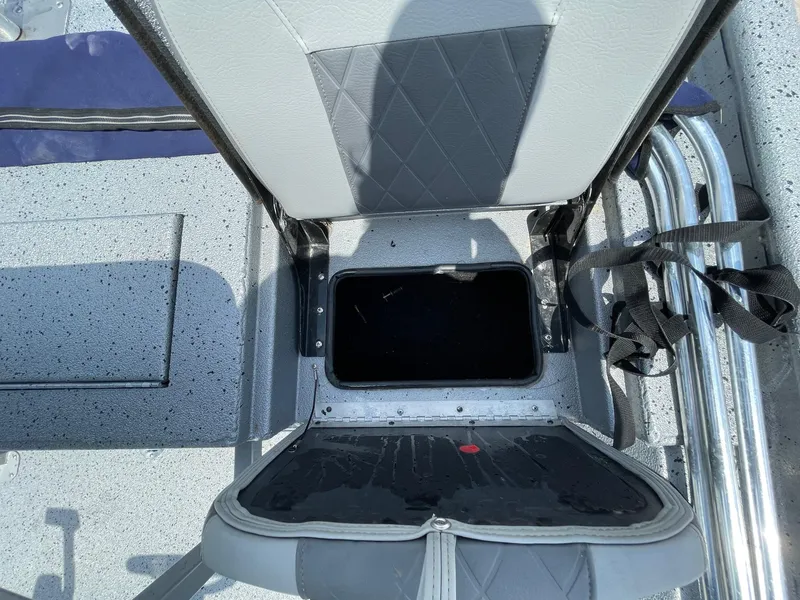 Slide: The Image of Open storage compartment on 2019 Xpress XP20CC boat with gray seating and straps. - 13