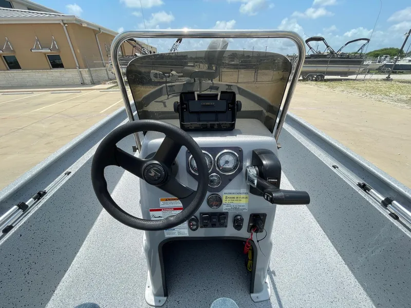 Slide: The Image of 2019 Xpress XP20CC boat console with steering wheel and controls, parked outdoors. - 19
