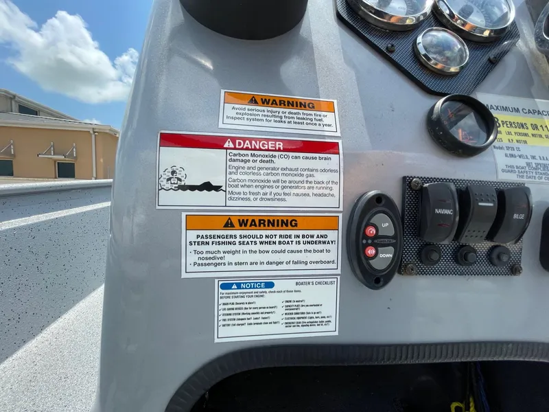 Slide: The Image of 2019 Xpress XP20CC boat dashboard with warning labels and control switches. - 22