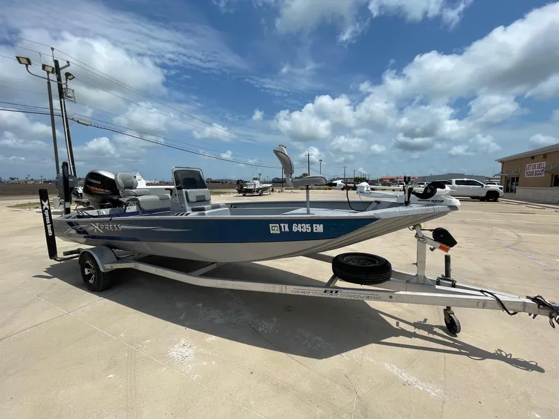 Slide: The Image of 2019 Xpress XP20CC boat on trailer under a partly cloudy sky. - 6