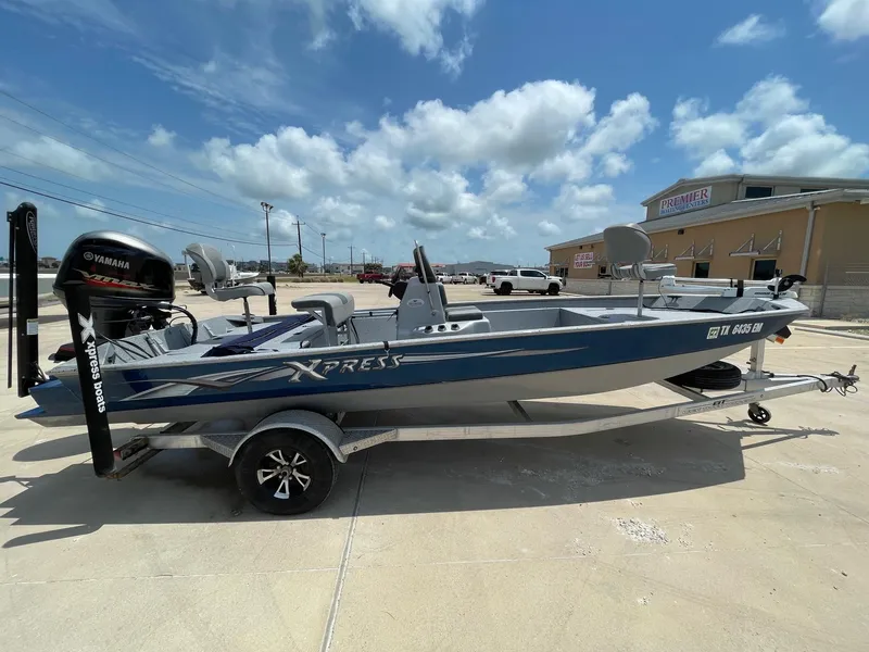 Slide: The Image of 2019 Xpress XP20CC boat with Yamaha motor, parked outdoors under a cloudy sky. - 7