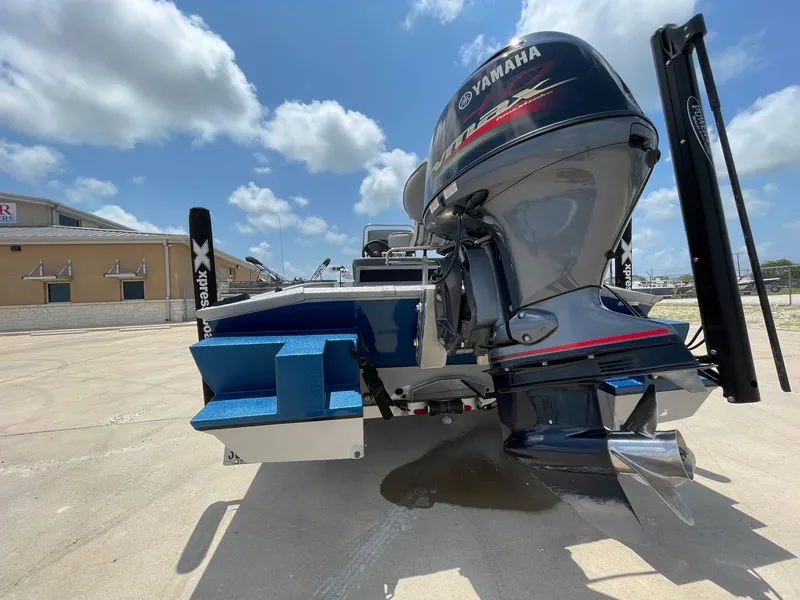 Slide: The Image of 2019 Xpress XP20CC boat with Yamaha outboard motor, parked outdoors under a blue sky. - 9