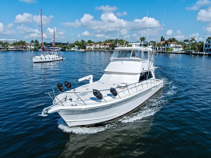 Slide: The Image of 2001 Riviera 48 yacht cruising in a scenic urban marina setting. - 14