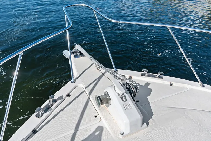 Slide: The Image of 2001 Riviera 48 yacht cruising on a sunny day, surrounded by waterfront homes and palm trees. - 19