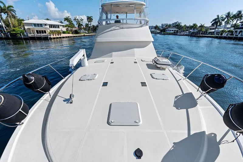 Slide: The Image of Riviera 48 yacht deck with davit crane, waterfront homes in background, 2001 model. - 20