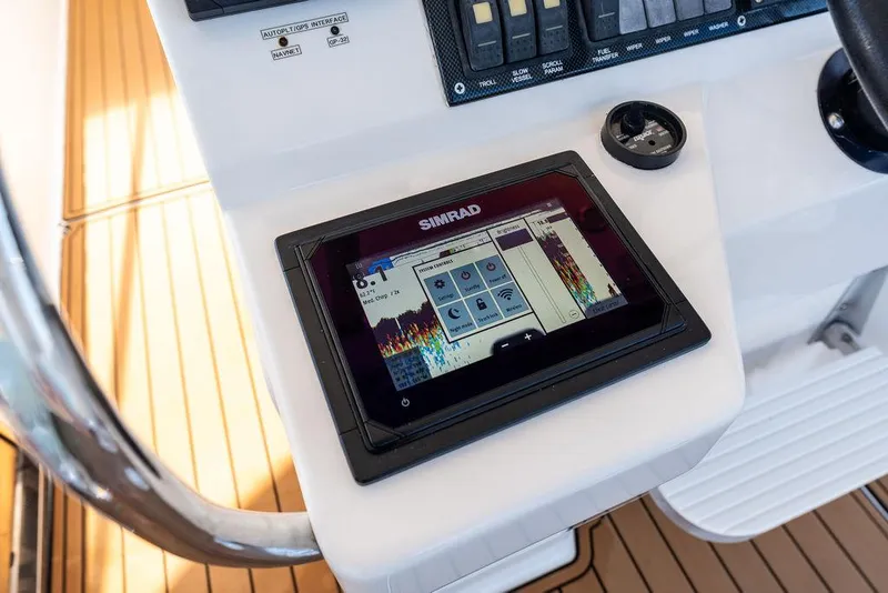 Slide: The Image of Cockpit of 2001 Riviera 48 yacht with steering wheel and control panel, overlooking marina. - 32
