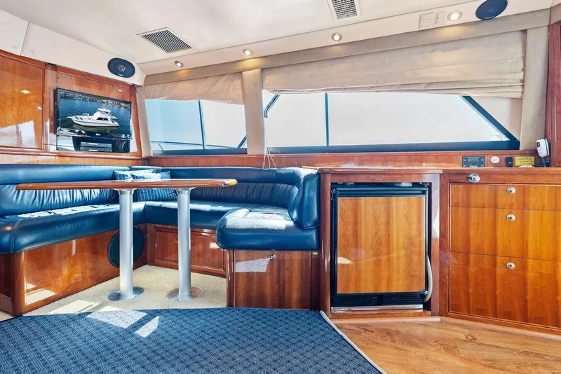 Slide: The Image of Luxurious interior of a 2001 Riviera 48 yacht with blue leather seating and wooden accents. - 40