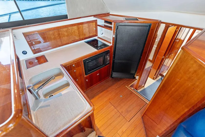 Slide: The Image of Luxurious 2001 Riviera 48 yacht kitchen with wood cabinetry and modern appliances. - 43