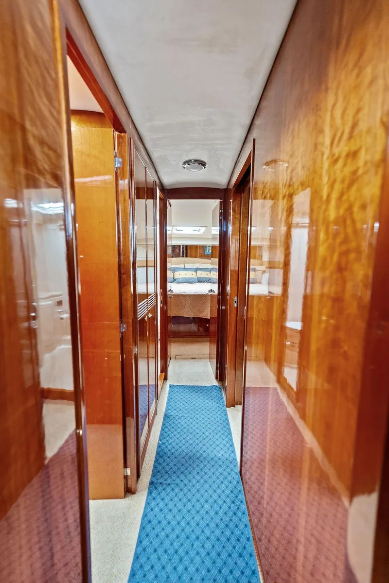 Slide: The Image of 2001 Riviera 48 yacht cabin with wooden door and cozy bunk beds. - 46