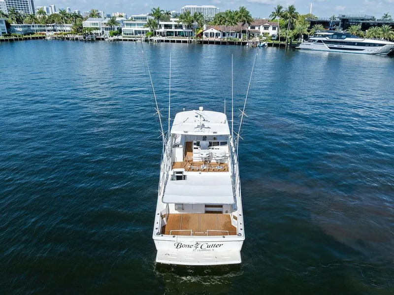Slide: The Image of 2001 Riviera 48 yacht on water, rear view, with coastal homes in the background. - 7