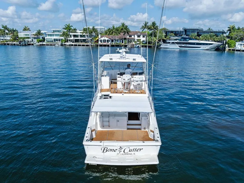 Slide: The Image of 2001 Riviera 48 yacht on water, rear view, clear sky, "Bone Cutter" name visible. - 8