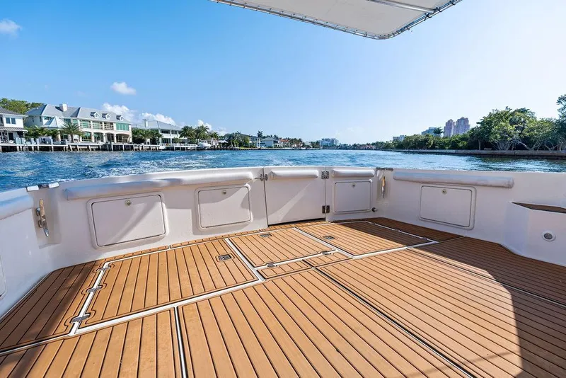 Slide: The Image of Spacious deck of 2001 Riviera 48 yacht with wooden flooring and waterfront view. - 26