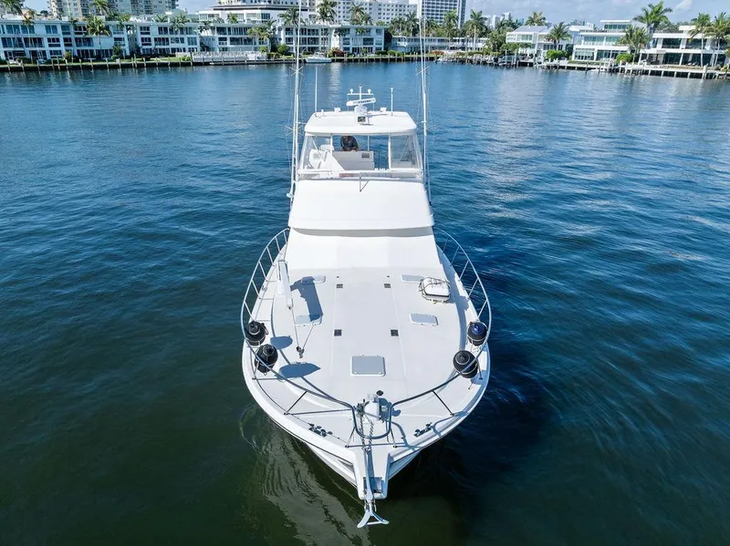 Slide: The Image of 2001 Riviera 48 yacht cruising on a sunny day with palm trees in the background. - 3