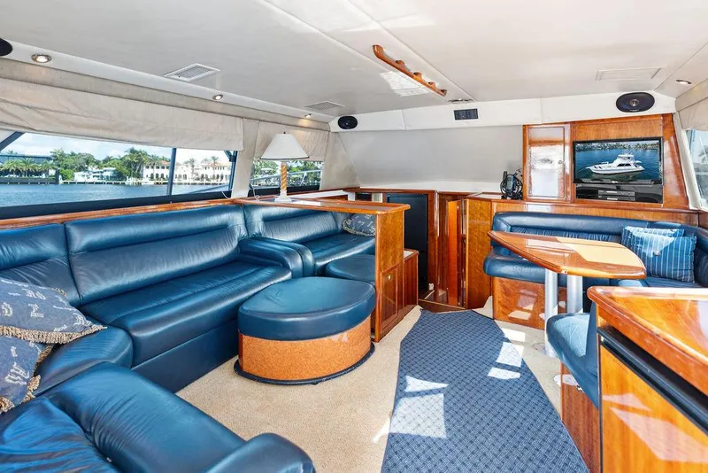 Slide: The Image of Luxurious interior of a 2001 Riviera 48 yacht with elegant wood finishes and blue seating. - 39