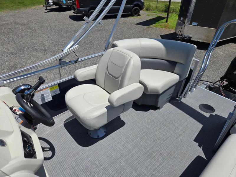 Slide: The Image of 2023 SunChaser Vista 18 LR pontoon boat interior with plush seating and steering console. - 12