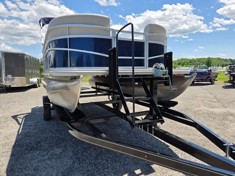 Slide: The Image of 2023 SunChaser Vista 18 LR pontoon boat on trailer under a bright blue sky. - 2