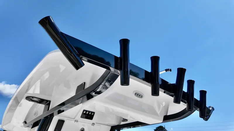 Slide: The Image of 2025 Sea Fox 248 Commander boat with rod holders against a clear blue sky. - 10