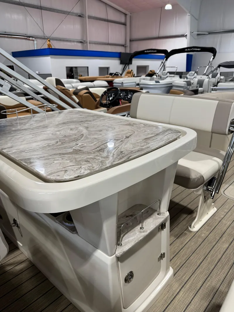 Slide: The Image of 2025 Avalon 2585 25 Catalina ENT boat interior with elegant seating and table in showroom. - 12
