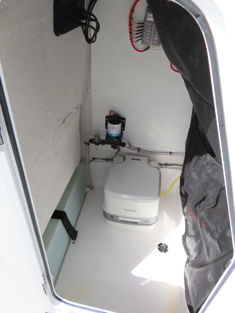 Slide: The Image of 2023 Sportsman Heritage 231 Center Console interior with portable toilet and plumbing. - 19