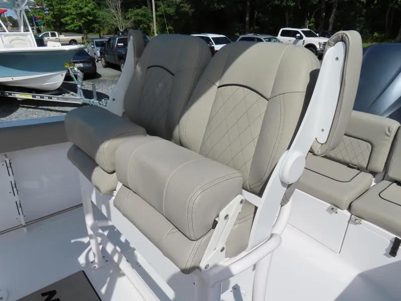 Slide: The Image of 2023 Sportsman Heritage 231 Center Console boat seats, featuring beige upholstery and diamond stitching. - 21