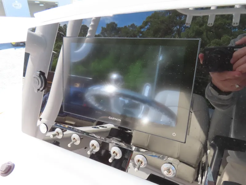 Slide: The Image of 2023 Sportsman Heritage 231 Center Console dashboard with Garmin display and control switches. - 24