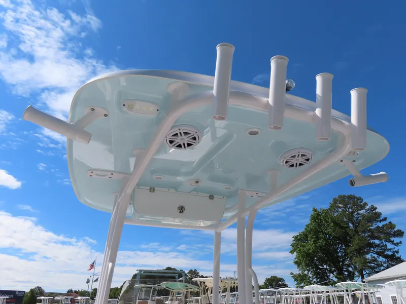 Slide: The Image of 2023 Sportsman Heritage 231 Center Console boat top with rod holders and speakers against blue sky. - 29