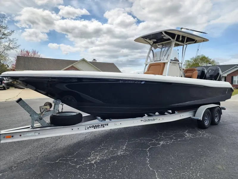 Slide: The Image of 2010 Blackwood 270 boat on trailer, parked in residential area under cloudy sky. - 1