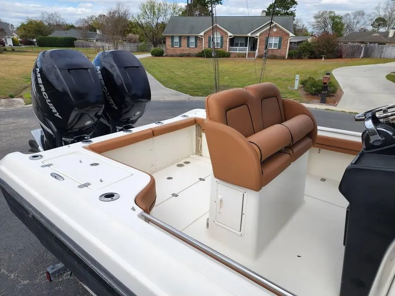 Slide: The Image of 2010 Blackwood 270 boat with dual Mercury engines and tan seating, parked in a suburban driveway. - 14