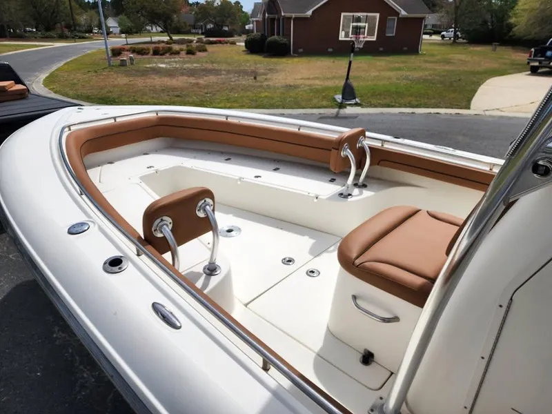 Slide: The Image of 2010 Blackwood 270 boat interior with tan seating and white deck, parked in residential area. - 16