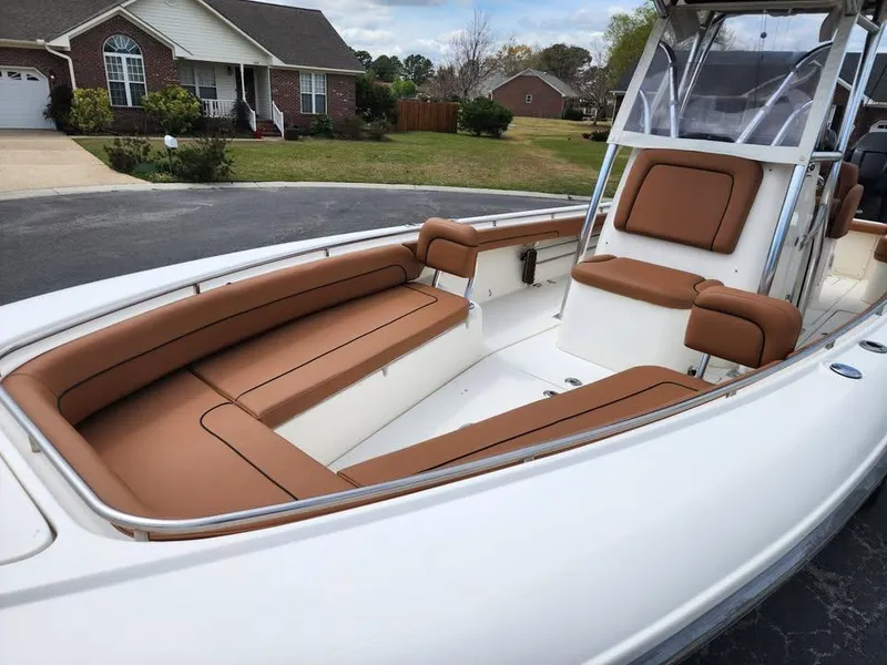 Slide: The Image of 2010 Blackwood 270 boat with tan seating, parked in a residential driveway. - 17