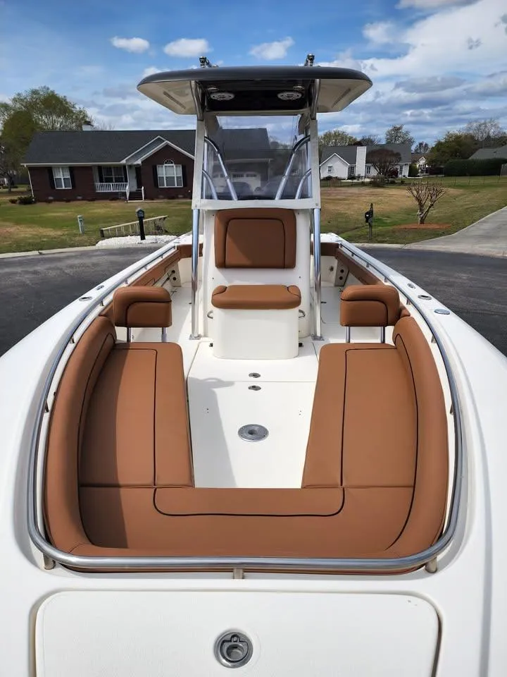 Slide: The Image of 2010 Blackwood 270 boat with tan seating, center console, and T-top in a suburban setting. - 18