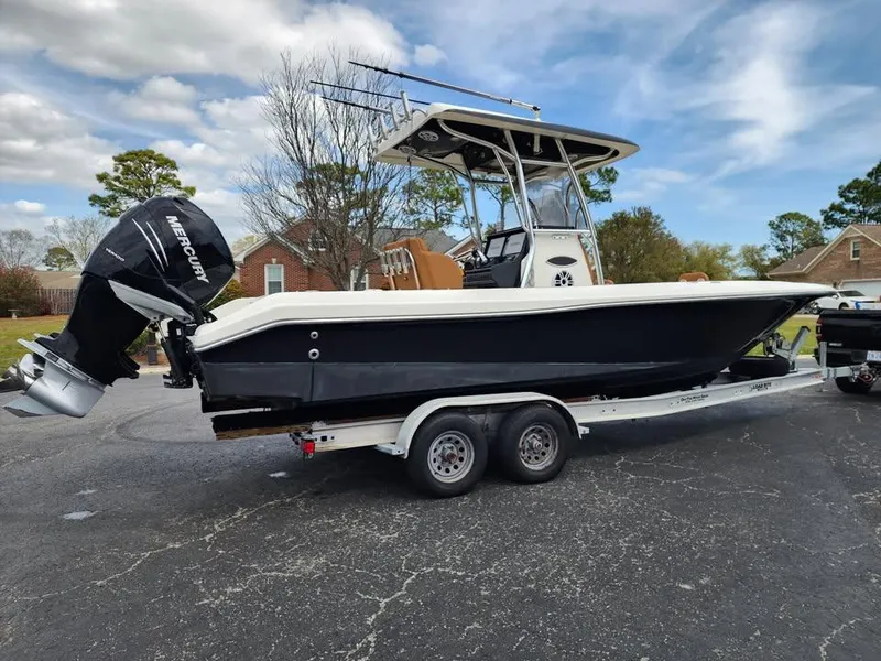 Slide: The Image of 2010 Blackwood 270 boat on trailer with Mercury outboard, parked outdoors. - 2
