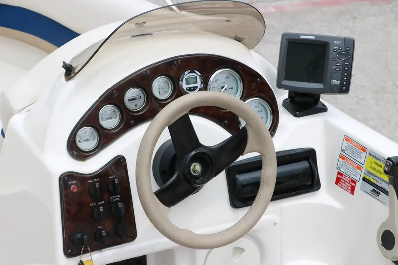 Slide: The Image of Dashboard of a 2006 Hurricane GS 172 boat with steering wheel and gauges. - 14