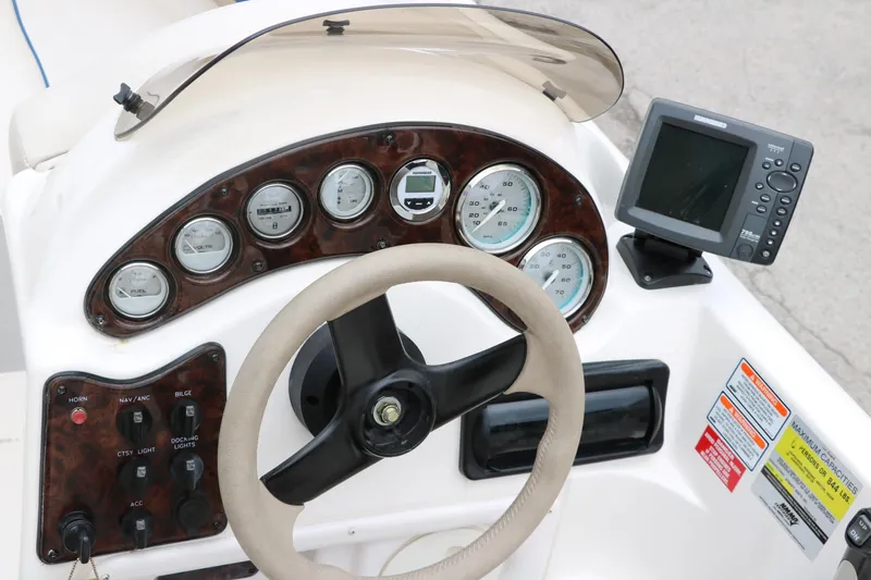 Slide: The Image of 2006 Hurricane GS 172 boat dashboard with steering wheel and navigation instruments. - 20