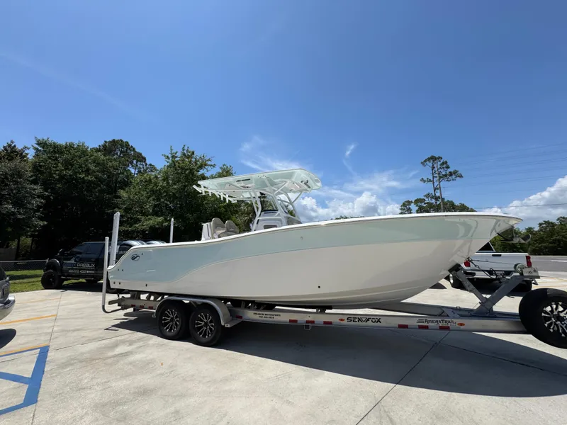 Slide: The Image of 2022 Sea Fox 288 Commander boat on trailer, parked outdoors under clear sky. - 11