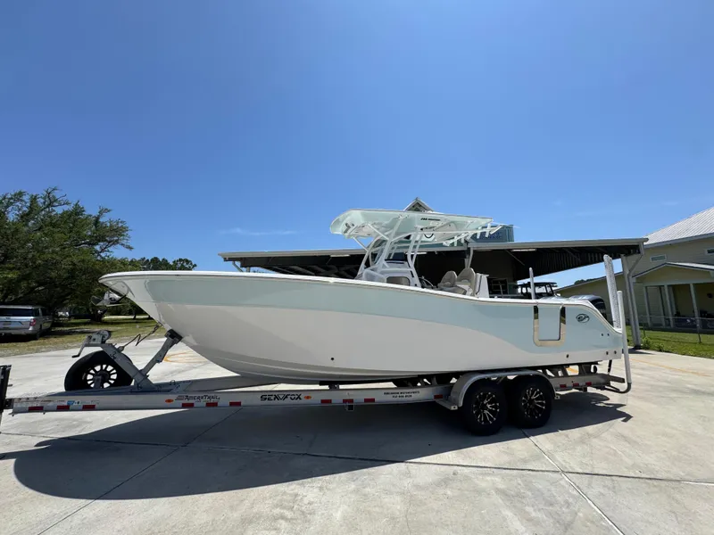 Slide: The Image of 2022 Sea Fox 288 Commander boat on trailer, parked outdoors under clear blue sky. - 2