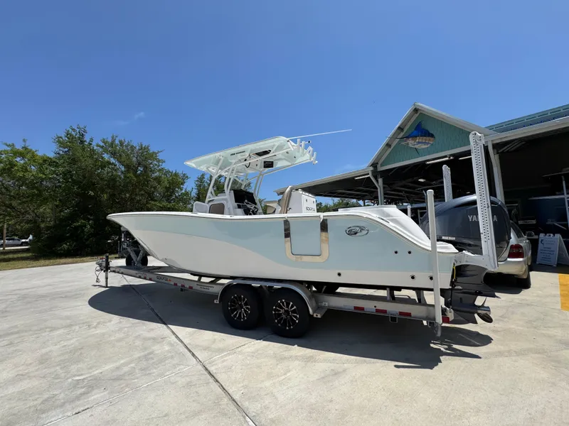 Slide: The Image of 2022 Sea Fox 288 Commander boat on trailer, parked outdoors under clear blue sky. - 22