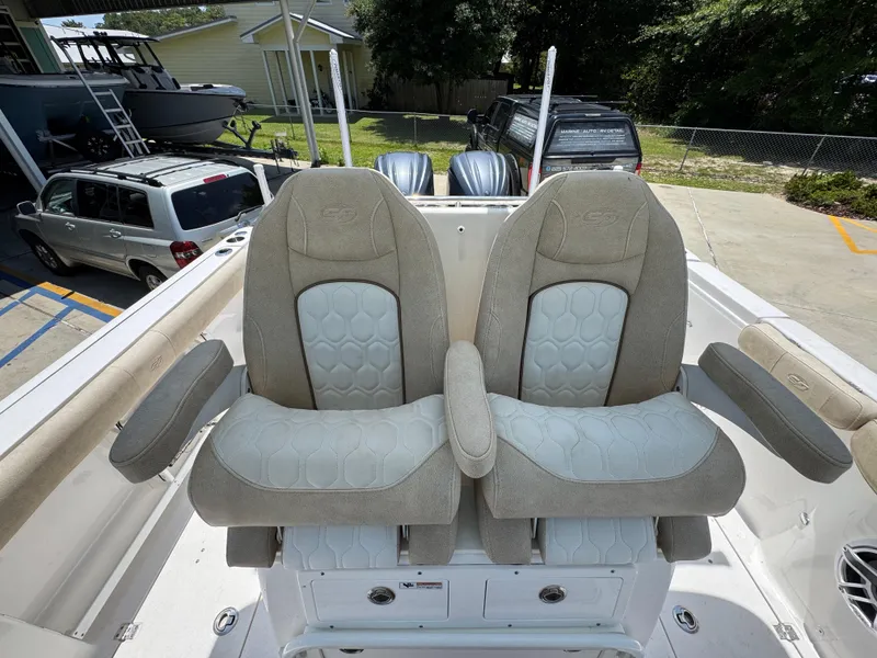 Slide: The Image of 2022 Sea Fox 288 Commander boat seats with armrests, parked in a driveway. - 36
