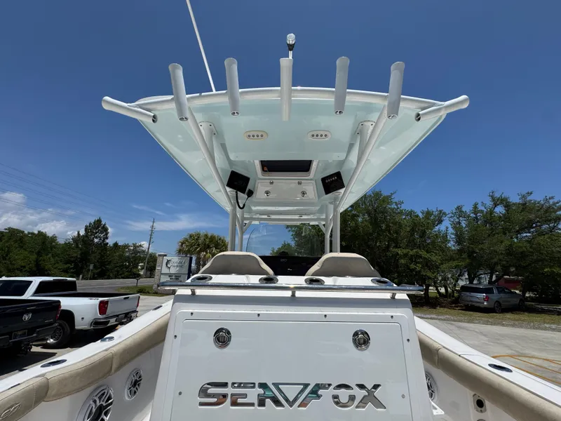 Slide: The Image of 2022 Sea Fox 288 Commander boat, view of helm and T-top under clear blue sky. - 48