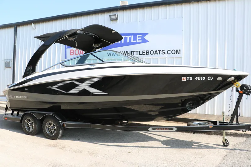 Slide: The Image of 2014 Regal 2500 RX Bowrider boat on trailer, black and white design, parked outside dealership. - 14