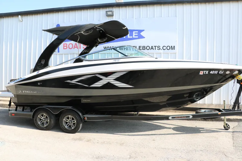 Slide: The Image of 2014 Regal 2500 RX Bowrider boat on trailer, black and white design, parked outside. - 15