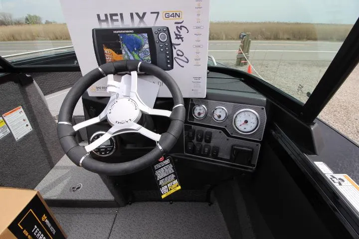 Slide: The Image of 2025 Lund 2075 Tyee boat dashboard with steering wheel and Helix 7 G4N fish finder. - 4