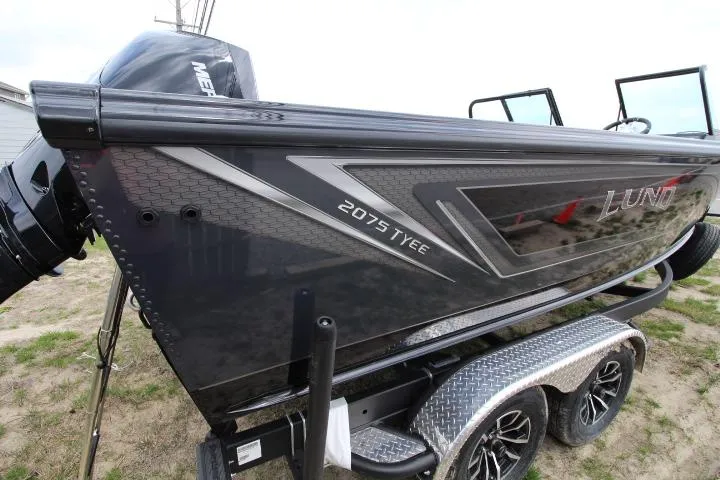Slide: The Image of 2025 Lund 2075 Tyee boat on trailer, side view, sleek design, outdoor setting. - 9