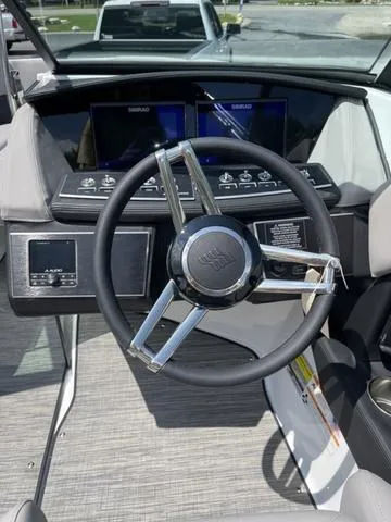 Slide: The Image of 2023 Four Winns H4 boat dashboard with steering wheel and digital displays. - 6