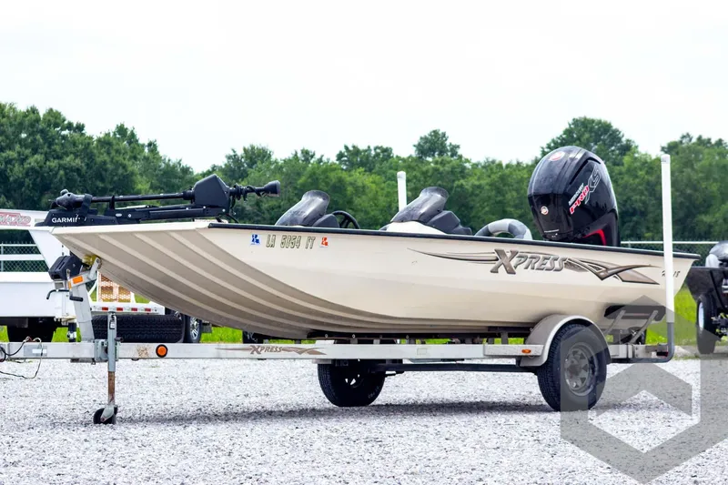 Slide: The Image of 2008 Xpress HD18SCA boat on trailer, parked outdoors with trees in background. - 1
