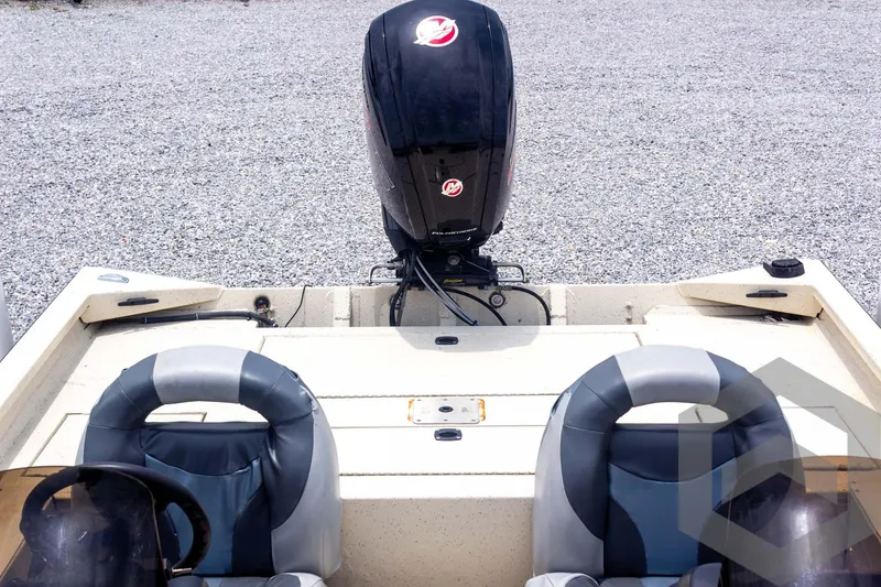 Slide: The Image of 2008 Xpress HD18SCA boat with dual seats and outboard motor, parked on gravel. - 24