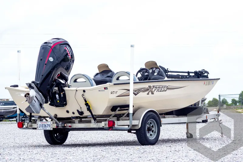 Slide: The Image of 2008 Xpress HD18SCA boat on trailer with outboard motor, parked on gravel. - 4